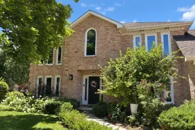 Two-story brick home in Lisle, IL with new white replacement windows, including an arched-top window above the front entry